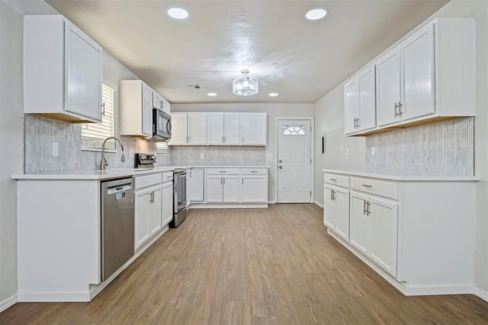 Tessa Hood Realtor – Refreshed kitchen with white cabinetry, tile backsplash and stainless appliances at 1112 County Street 2910, Tuttle Oklahoma