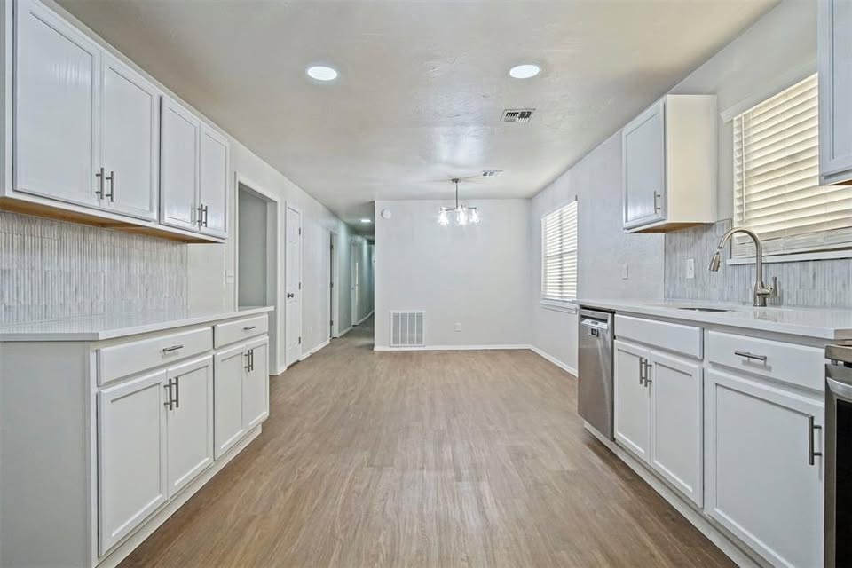 Tessa Hood Realtor – Kitchen with ample white cabinetry and open hallway at 1112 County Street 2910, Tuttle Oklahoma