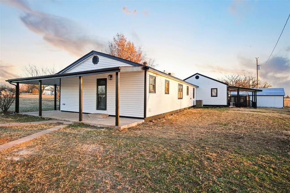 Tessa Hood Realtor – Side exterior view of ranch home with covered porch and outbuildings at 1112 County Street 2910, Tuttle Oklahoma