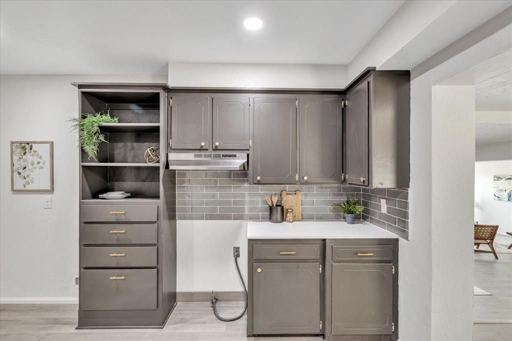 Tessa Hood Realtor – Kitchen close-up showing grey cabinets with gold hardware and grey subway tile backsplash at 7400 Lakewood Dr, Mustang Oklahoma