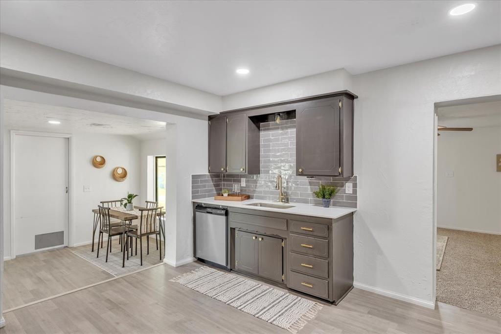 Tessa Hood Realtor – Kitchen with stainless sink, stainless dishwasher, and view to dining at 7400 Lakewood Dr, Mustang Oklahoma