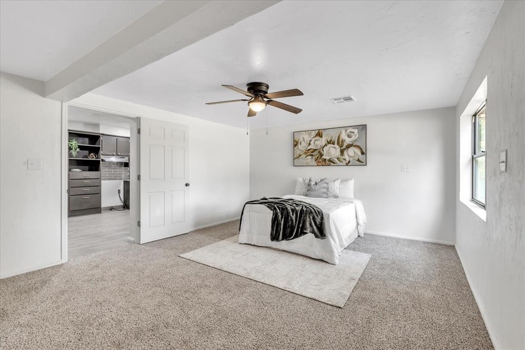 Tessa Hood Realtor – Primary bedroom showing spacious layout and door to remodeled bathroom at 7400 Lakewood Dr, Mustang Oklahoma