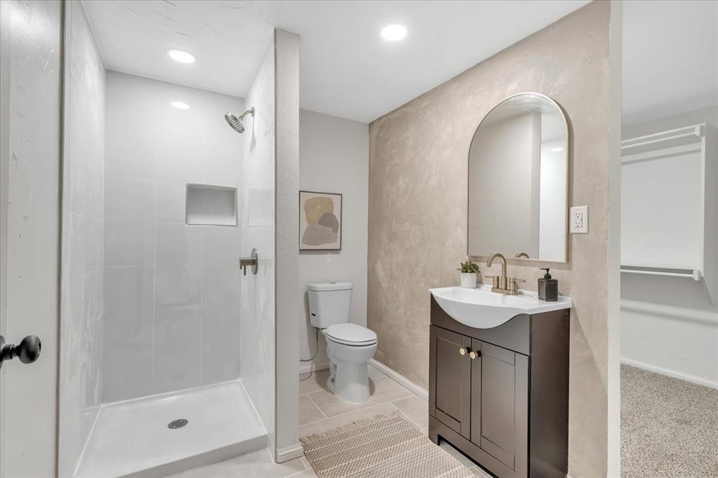 Tessa Hood Realtor – Remodeled primary bathroom with walk-in shower, new vanity, and arched mirror at 7400 Lakewood Dr, Mustang Oklahoma