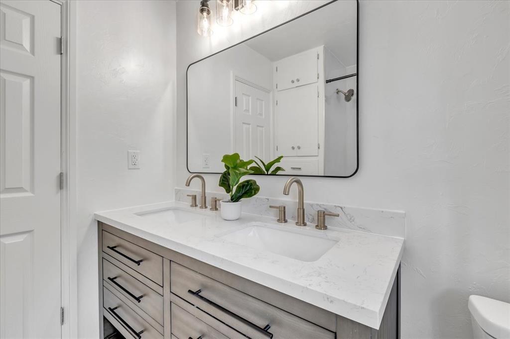 Tessa Hood Realtor – Secondary bathroom with new quartz vanity, black-frame mirror, and brushed nickel fixtures at 7400 Lakewood Dr, Mustang Oklahoma