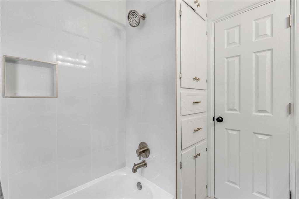 Tessa Hood Realtor – Secondary bathroom tub-shower with tile surround and built-in linen storage at 7400 Lakewood Dr, Mustang Oklahoma