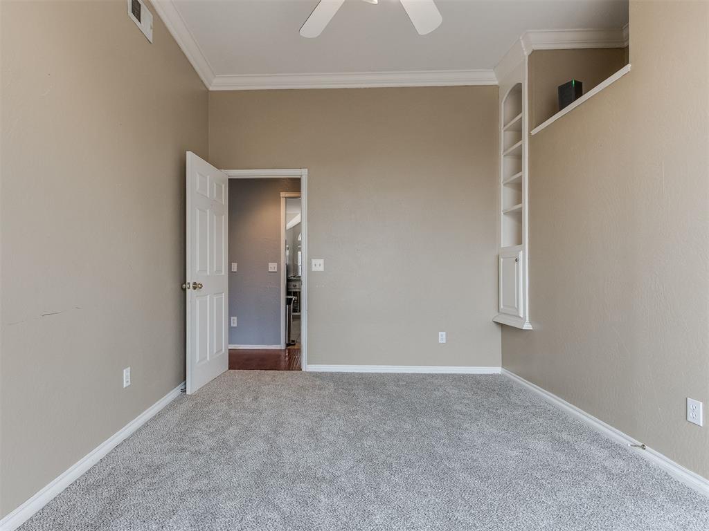 Tessa Hood Realtor – Bedroom 3 with built-in shelving and crown molding at 5879 Mockingbird Ln, Blanchard Oklahoma