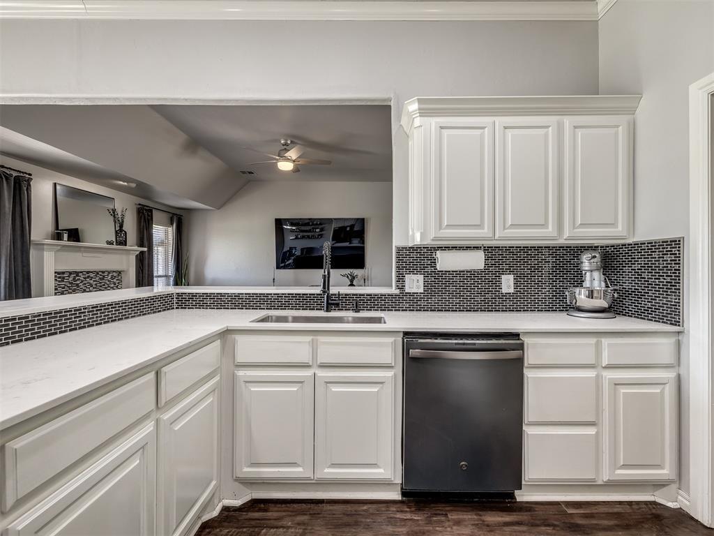 Tessa Hood Realtor – Kitchen with quartz countertops, white cabinets, and dark backsplash at 6910 Rolling Meadows Dr, Tuttle Oklahoma