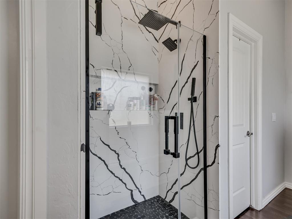 Tessa Hood Realtor – Remodeled walk-in shower with marble tile and black fixtures at 6910 Rolling Meadows Dr, Tuttle Oklahoma