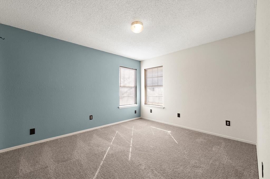 Tessa Hood Realtor – Bedroom 2 with blue accent wall and two windows at 2028 Rose Court, Norman Oklahoma