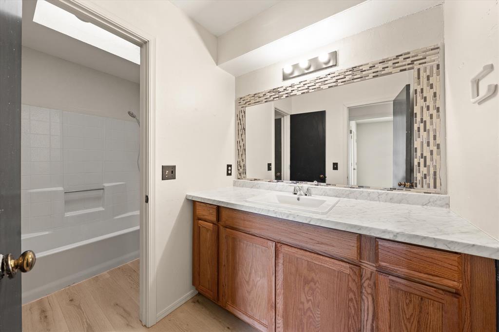 Tessa Hood Realtor – Upstairs bathroom vanity with tiled mirror frame at 2028 Rose Court, Norman Oklahoma