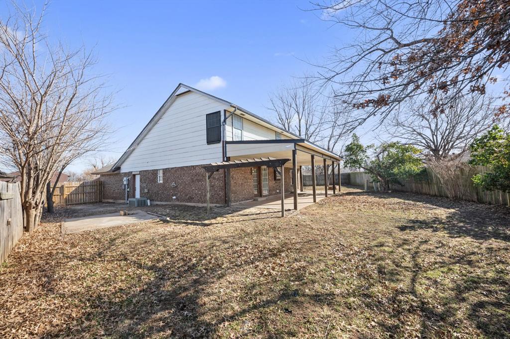 Tessa Hood Realtor – Rear exterior view showing two-story profile and spacious backyard at 2028 Rose Court, Norman Oklahoma