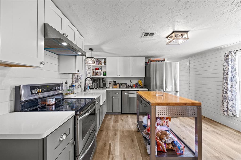 Tessa Hood Realtor – Kitchen with white and gray cabinetry, stainless appliances, and butcher block island at 21063 State Hwy 76, Blanchard Oklahoma