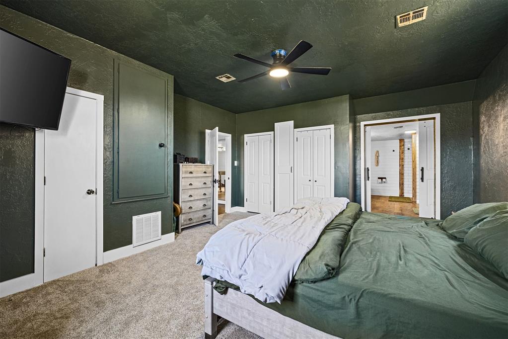 Tessa Hood Realtor – Primary bedroom with dark green accent walls and ceiling fan at 21063 State Hwy 76, Blanchard Oklahoma