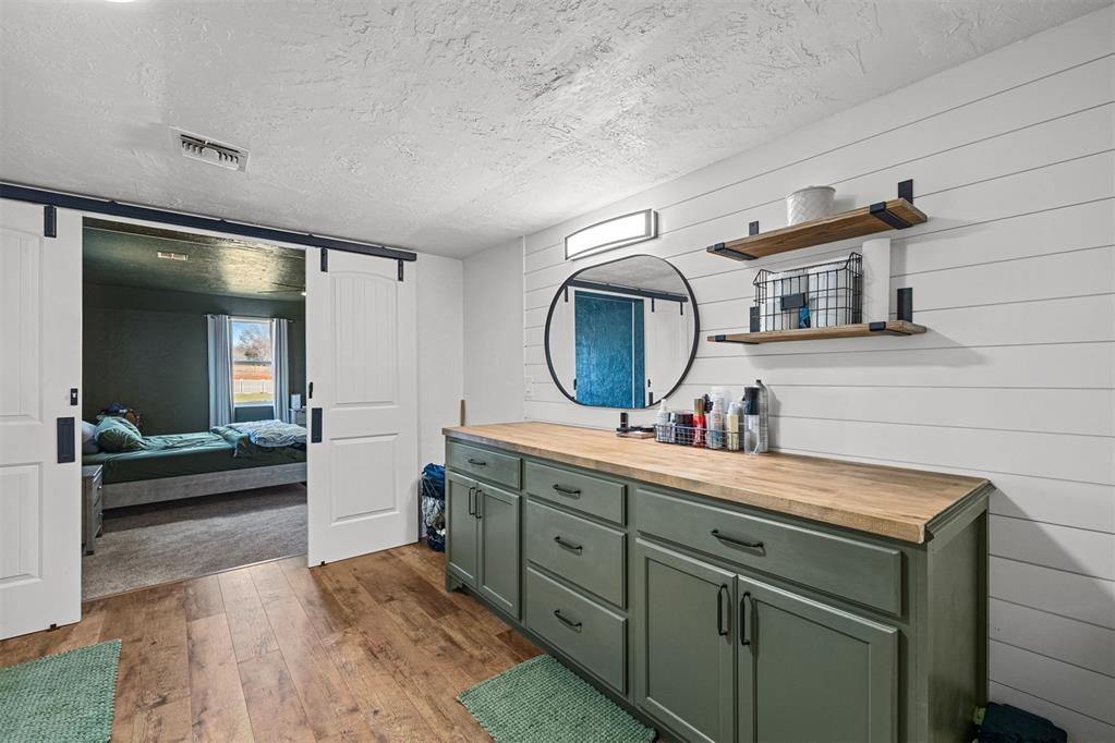 Tessa Hood Realtor – Primary bathroom with green cabinetry and barn door entry at 21063 State Hwy 76, Blanchard Oklahoma